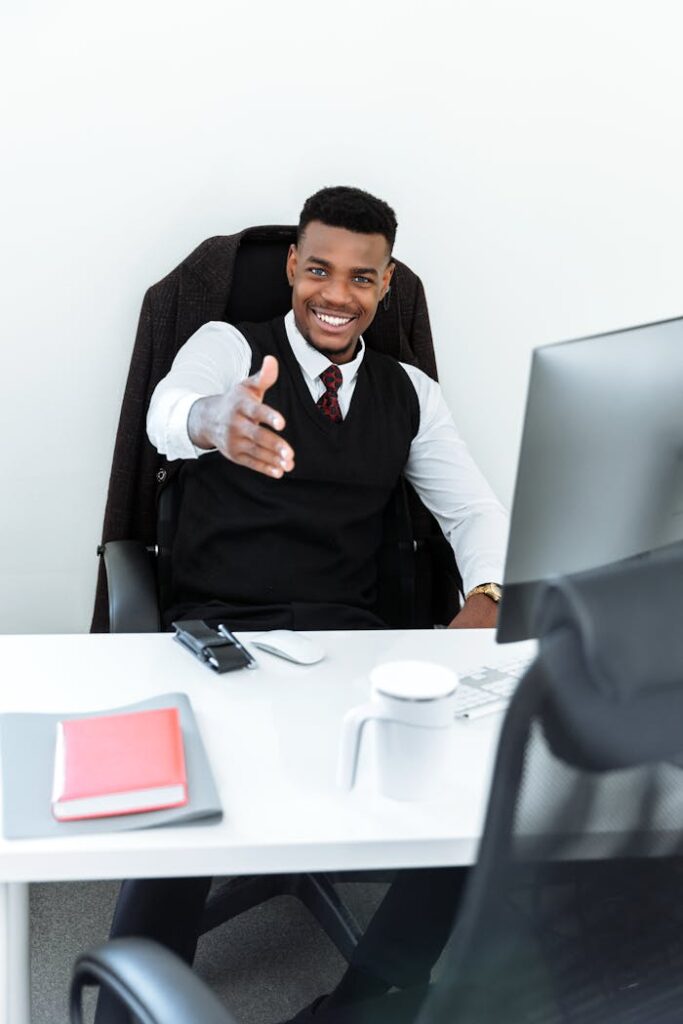 Man in Black Vest Sitting Behind a Desk